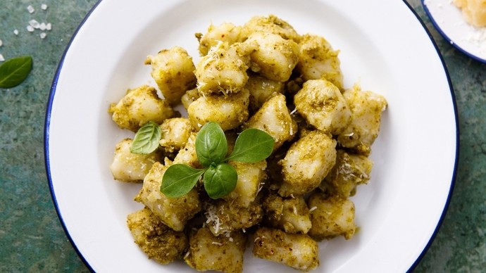 Creamy vegan gnocchi served on a white plate with a green garnish