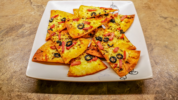 Platiaid o sglodion tortila crensiog gyda saws tomatos a chaws ar eu pennau