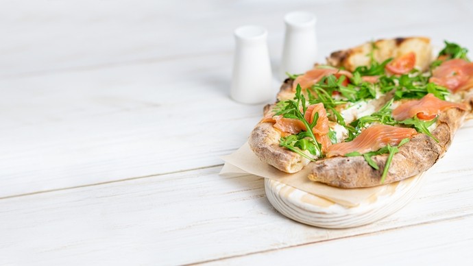crispy pieces of bread topped with rich smoked salmon slices, wild rocket and tomato