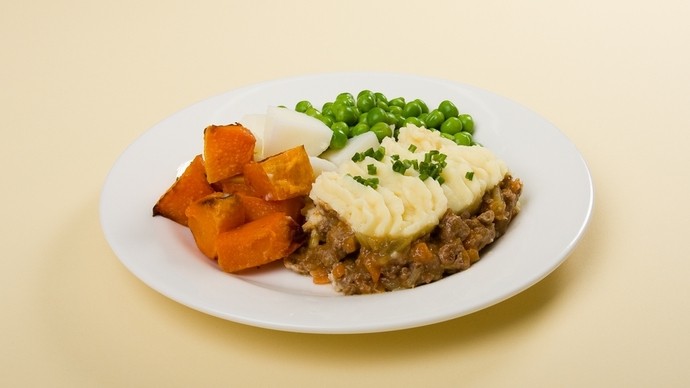 a plate of spiced pumpkin slices, mince and a layer of creamy mash