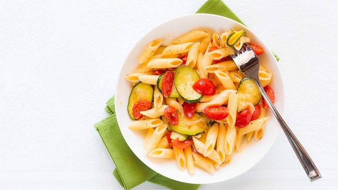 a pasta topped with a light tomato sauce and sliced courgettes