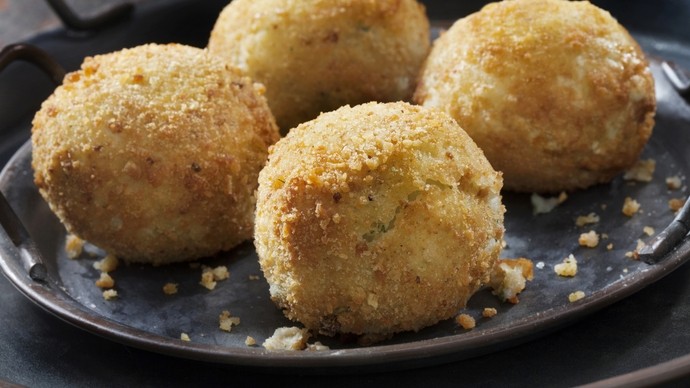 Round golden and crisp potato croquettes served on a plate