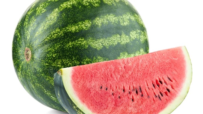 a full watermelon beside a slice of melon