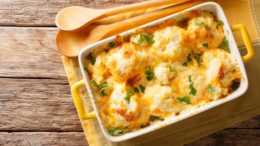 A rich dish of cauliflower covered in a creamy cheese sauce