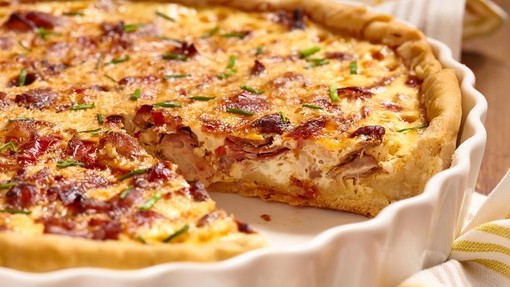 a partially served dish of baked red onion and creamy goats cheese tart
