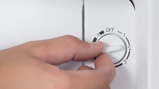 A white hand turns a dial in a fridge, the dial is labelled 'Off, 1, 2, 3'