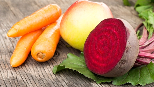 A few carrots, an apple and beetroot on a table