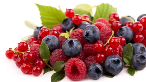 a pile of fresh summer berries - blueberries and raspberries