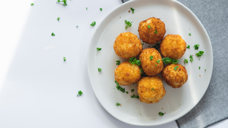 crispy arancini balls dusted with a herb garnish