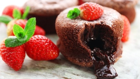 A rich chocolate pudding with a melted chocolate centre served with fresh strawberries