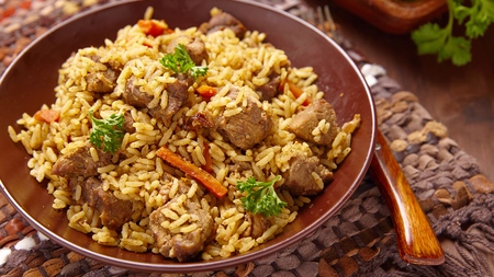 Bowl of lamb biryani at a table ready to be eaten