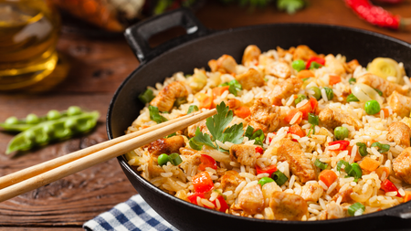 a plate of colourful rice mixed with bright vegetables e.g. garden peas