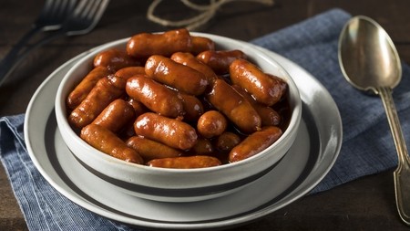 a pot of mini sausages covered in a rich brown sauce