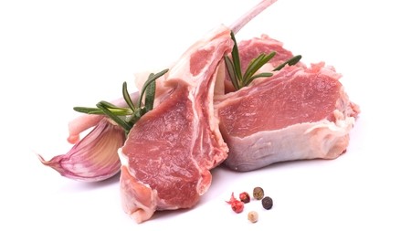 a couple of raw lamb chops with a sprig of herb